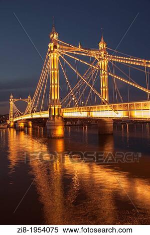 Stock Photography - Albert Bridge on the river Thames, connecting Chelsea and Battersea on the south, London, England. 4, 000 bulbs illuminate Albert Bridge at night.. Fotosearch