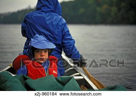 Algonquin Provincial Park, Ontario - Mariel West, 5, rides on Ragged Lake in a canoe during a rainstorm while on a camping trip MR View Large Photo Image Picture - Algonquin Provincial Park, Ontario - Mariel West, 5, rides on Ragged Lake in a canoe during a rainstorm while on a camping trip MR. Fotosearch