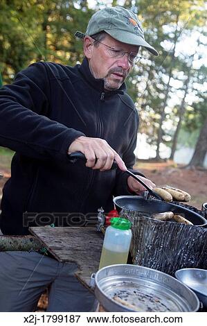 Algonquin Provincial Park, Ontario Canada - John West, 65, cooks breakfast during a canoe trip View Large Photo Image Stock Photo - Algonquin Provincial Park, Ontario Canada - John West, 65, cooks breakfast during a canoe trip. Fotosearch