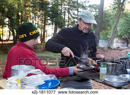 Algonquin Provincial Park, Ontario Canada - John West, 65, cooks pancakes for his son Joey, 13, during a canoe trip View Large Photo Image Stock Photo - Algonquin Provincial Park, Ontario Canada - John West, 65, cooks pancakes for his son Joey, 13, during a canoe trip. Fotosearch
