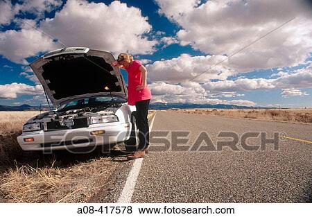 Along deserted stretch of highway, stranded woman waits for roadside help View Large Photo Image Stock Photo - Along deserted stretch of highway, stranded woman waits for roadside help. Fotosearch