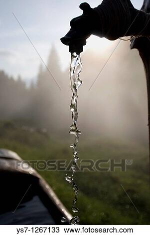 Stock Image - Alpine hut's spring, eastern Alps, Belluno, Italy. Fotosearch