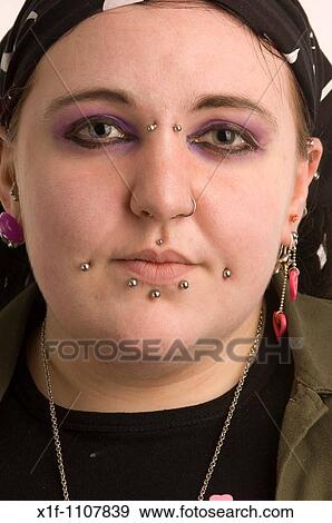 Stock Photo - Alternative goth punk young woman with studs in her face. Fotosearch