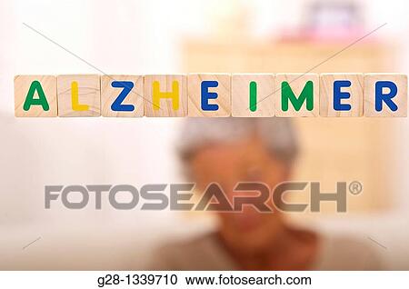 Stock Image - Alzheimer written in bright letters and behind, blurred the silhouette of a senior woman. Fotosearch