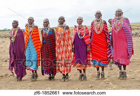 Stock Image - Amboseli National Park Kenya Africa safari Masai women welcome to village Amboseli Maasai, beads, red, color, line, smile, jump, 1. Fotosearch