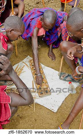 Amboseli National Park Kenya Africa safari Masai men playing Bao game on ground in village Amboseli Maasai, beads, red, color, play, compete, fun, excite, balls, cups, 1 View Large Photo Image Stock Image - Amboseli National Park Kenya Africa safari Masai men playing Bao game on ground in village Amboseli Maasai, beads, red, color, play, compete, fun, excite, balls, cups, 1. Fotosearch