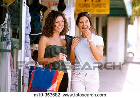 Stock Image - American and columbian friends shopping. Fotosearch