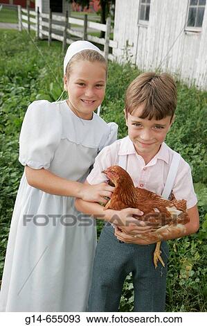 Stock Image - Amish Farm Tour, boy, girl, chicken. Shipshewana. Indiana. USA.. Fotosearch