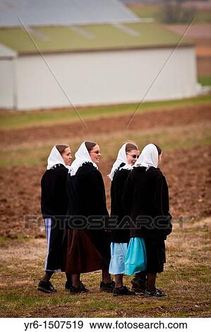 Stock Photo - Amish girls walk across a farm field in Gordonville, PA. Fotosearch