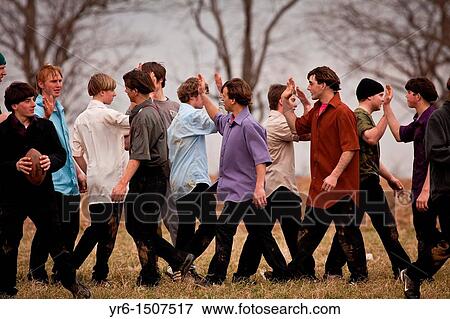 Stock Photo - Amish play football in a farm field during the Annual Mud Sale to support the Fire Department in Gordonville, PA. Fotosearch