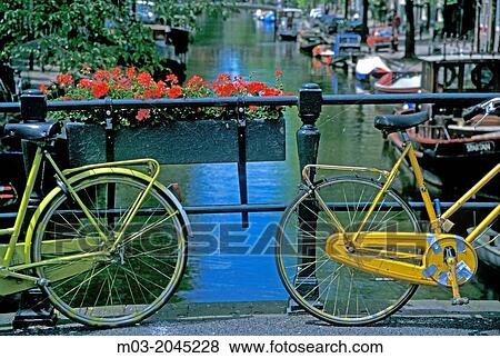 Amsterdam Netherlands Holland Europe two colorful bikes on bridge over canal. View Large Photo Image Stock Photo - Amsterdam Netherlands Holland Europe two colorful bikes on bridge over canal.. Fotosearch