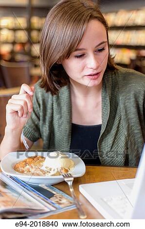 An 18 year old girl in a library eating a dessert. View Large Photo Image Stock Image - An 18 year old girl in a library eating a dessert.. Fotosearch