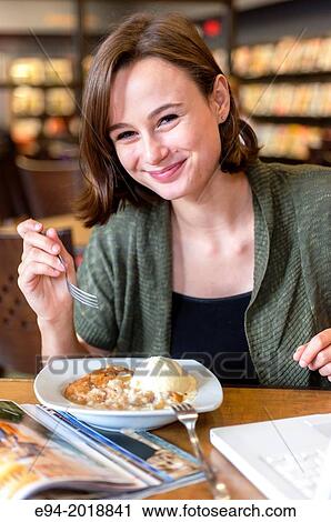 An 18 year old girl in a library eating a dessert. View Large Photo Image Stock Image - An 18 year old girl in a library eating a dessert.. Fotosearch