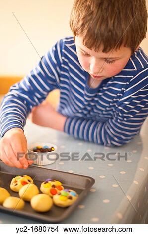 An 8 year old boy making cookies at home in England, Britain, Uk View Large Photo Image Picture - An 8 year old boy making cookies at home in England, Britain, Uk. Fotosearch