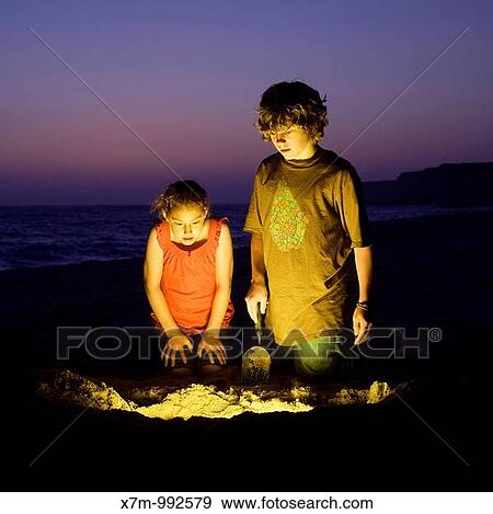 An adventurous boy and girl find treasure after digging on a sandy beach View Large Photo Image Stock Photo - An adventurous boy and girl find treasure after digging on a sandy beach. Fotosearch
