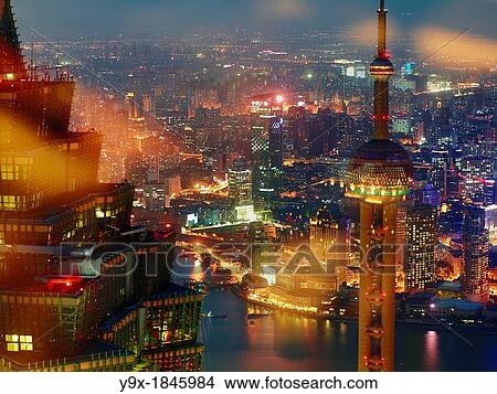 Picture - An aerial view overlooking Shanghai, China's financial district with prominent view of the Oriental Pearl Tower and the Jin Mao Tower at night. Fotosearch