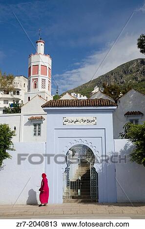 An Arab woman walks past mosque in Chefchaouen, Morocco. View Large Photo Image Stock Image - An Arab woman walks past mosque in Chefchaouen, Morocco.. Fotosearch