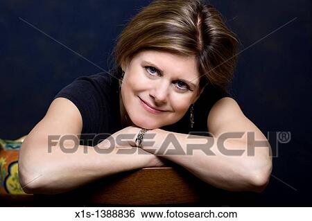 Stock Photograph - An attractive woman in jeans and a blue shirt. Fotosearch