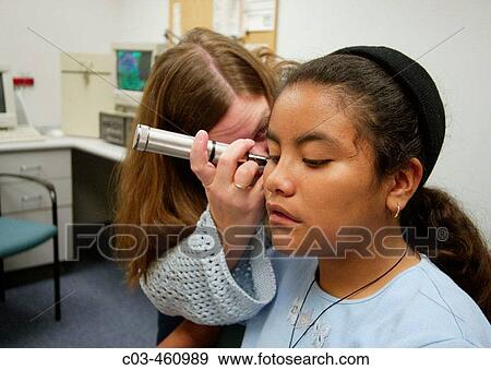 An audiologist examines the ear of a hearing impaired adolescent Hispanic girl at a speech and hearing clinic in Orange, California View Large Photo Image Stock Photo - An audiologist examines the ear of a hearing impaired adolescent Hispanic girl at a speech and hearing clinic in Orange, California. Fotosearch