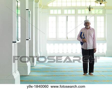 Stock Image - An elder man praying in a mosque. Fotosearch