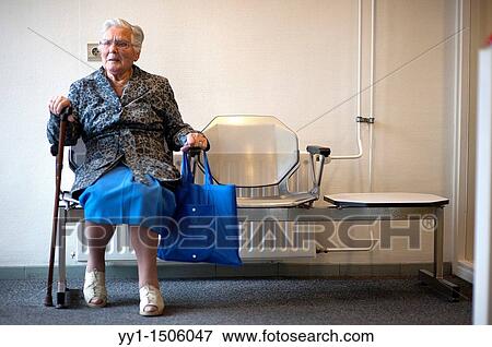 An elderly inhabitant of a Rotterdam nursing home, waiting for her taxi, near the entrance of her home. View Large Photo Image Stock Photo - An elderly inhabitant of a Rotterdam nursing home, waiting for her taxi, near the entrance of her home.. Fotosearch
