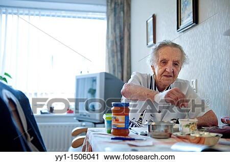 Stock Image - An elderly resident of a nursing home having breakfast at her private breakfast table.. Fotosearch
