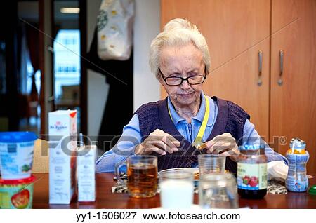 Stock Photo - An elderly resident of a nursing home having breakfast at the communal breakfast table.. Fotosearch