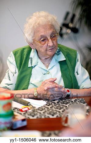 Stock Photograph - An elderly resident of a nursing home having breakfast at the communal breakfast table.. Fotosearch