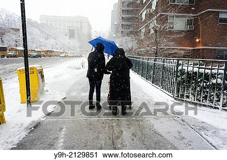 An elderly woman with her aide maneuver through the snow in the Chelsea neighborhood of New York. View Large Photo Image Stock Image - An elderly woman with her aide maneuver through the snow in the Chelsea neighborhood of New York.. Fotosearch