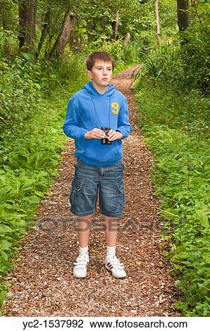 An eleven year old boy birdwatching with binoculars at Fairhaven woodland and water garden in South Walsham, Norfolk, England, Britain, Uk View Large Photo Image Stock Image - An eleven year old boy birdwatching with binoculars at Fairhaven woodland and water garden in South Walsham, Norfolk, England, Britain, Uk. Fotosearch
