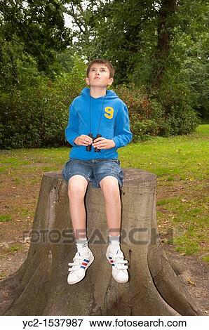 Stock Photo - An eleven year old boy birdwatching with binoculars at Fairhaven woodland and water garden in South Walsham, Norfolk, England, Britain, Uk. Fotosearch