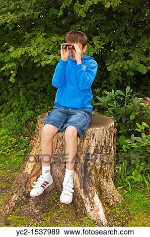 An eleven year old boy birdwatching with binoculars at Fairhaven woodland and water garden in South Walsham, Norfolk, England, Britain, Uk View Large Photo Image Stock Photo - An eleven year old boy birdwatching with binoculars at Fairhaven woodland and water garden in South Walsham, Norfolk, England, Britain, Uk. Fotosearch
