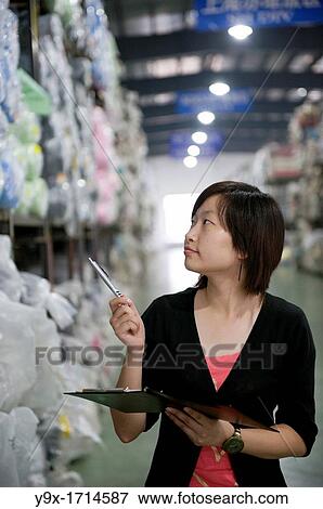 An employee at the New Wide Knitting and Dyeing Warehouse doing an inventory check View Large Photo Image Stock Photo - An employee at the New Wide Knitting and Dyeing Warehouse doing an inventory check. Fotosearch