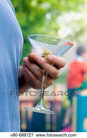 An empty stemmed martini glass held by thirsty host age 38, St Paul, Minnesota, USA View Large Photo Image Stock Photo - An empty stemmed martini glass held by thirsty host age 38, St Paul, Minnesota, USA. Fotosearch