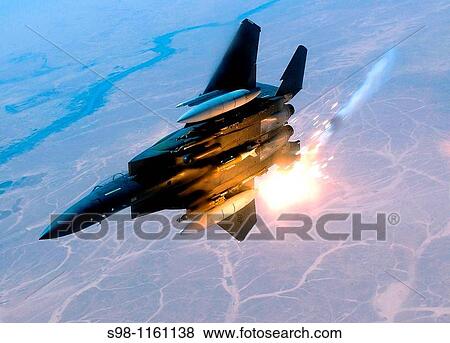 Stock Photo - An F-15E Strike Eagle pops flairs during a combat sortie in Southwest Asia The F-15E? s primary role in Afghanistan is providing close-air support for ground troops. Fotosearch