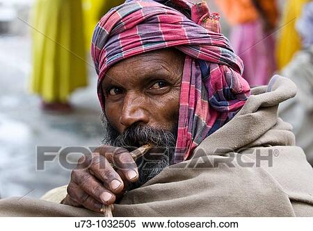 Stock Photography - An Indian man brushes his teeth early morning. Photo taken in Calcutta.. Fotosearch