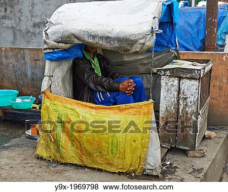 An Indian man sits in a homemade shelter made of tarp and sacks. View Large Photo Image Stock Photo - An Indian man sits in a homemade shelter made of tarp and sacks.. Fotosearch
