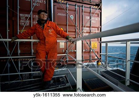 An Indonesian seaman or sailor on the container-vessel MV Flintercape, during a journey from Rotterdam, Netherlands, to Sundsvall, Sweden. The man is an? Able Seaman?, who generally works on deck, and now enjoys the view over the Baltic Sea for a moment. View Large Photo Image Stock Photography - An Indonesian seaman or sailor on the container-vessel MV Flintercape, during a journey from Rotterdam, Netherlands, to Sundsvall, Sweden. The man is an? Able Seaman?, who generally works on deck, and now enjoys the view over the Baltic Sea for a moment.. Fotosearch