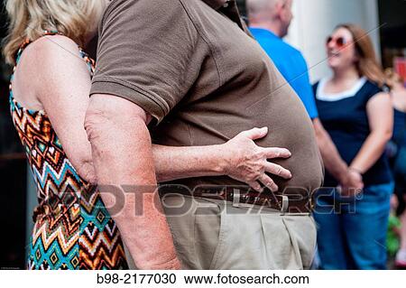 An obese man is embraced from the rear by a woman. View Large Photo Image Stock Image - An obese man is embraced from the rear by a woman.. Fotosearch