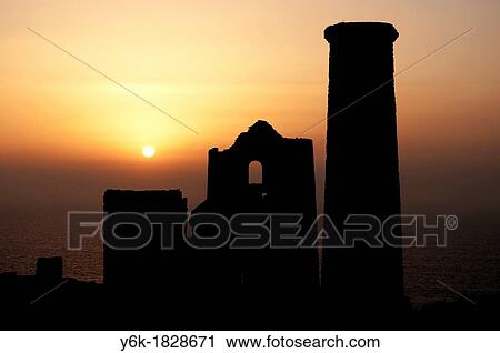 Stock Image - an old cornish tin mine with the setting sun as a background. Fotosearch