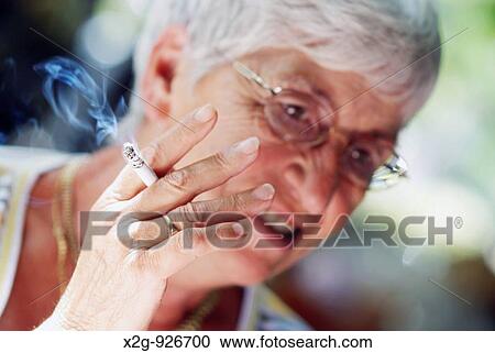 An old lady smoking a cigarette View Large Photo Image Stock Image - An old lady smoking a cigarette. Fotosearch
