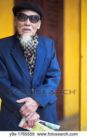 An old man in a blue suit, wearing an artist hat and sunglasses at a temple in Vietnam View Large Photo Image Stock Photography - An old man in a blue suit, wearing an artist hat and sunglasses at a temple in Vietnam. Fotosearch