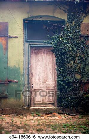 Stock Photograph - An old wooden door on an old building in an alley way. Fotosearch