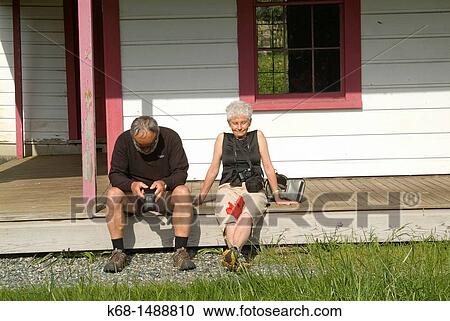 an older couple relaxes on the porch of a house View Large Photo Image Stock Image - an older couple relaxes on the porch of a house. Fotosearch