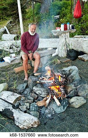 an older man sits by a campfire on a beach on Nootka Island, BC, Canada View Large Photo Image Stock Image - an older man sits by a campfire on a beach on Nootka Island, BC, Canada. Fotosearch