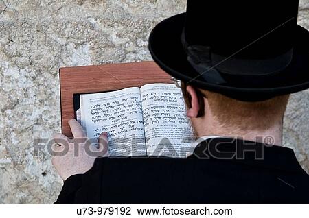 Stock Image - An Orthodox Jewish man praying by the wailing wall in the old city of Jerusalem, Israel.. Fotosearch