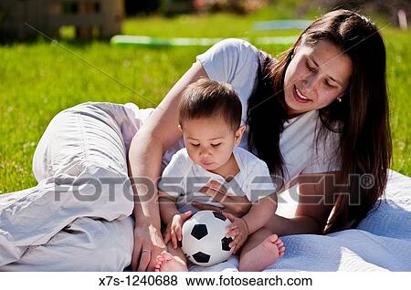 An outside portrait of a loving mother and her baby boy who holds a soccer ball View Large Photo Image Stock Photo - An outside portrait of a loving mother and her baby boy who holds a soccer ball. Fotosearch