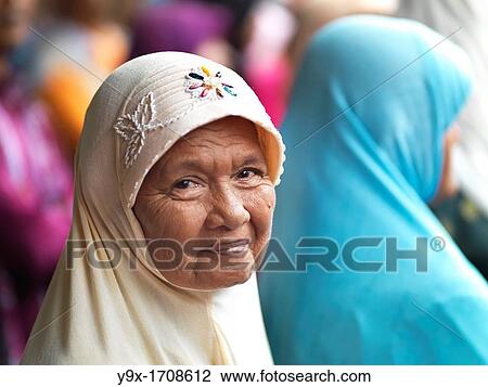 An smiling elderly Muslim woman wearing a embroidered hijab View Large Photo Image Stock Image - An smiling elderly Muslim woman wearing a embroidered hijab. Fotosearch