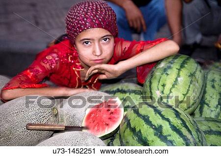 An Uighur girl sitting by tasty melons and watermelons sold on the streets of Kashgar. View Large Photo Image Stock Image - An Uighur girl sitting by tasty melons and watermelons sold on the streets of Kashgar.. Fotosearch