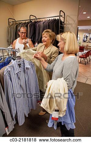 Stock Photo - An unemployed Hispanic man proudly gets new business clothing from Working Wardrobes,. Fotosearch